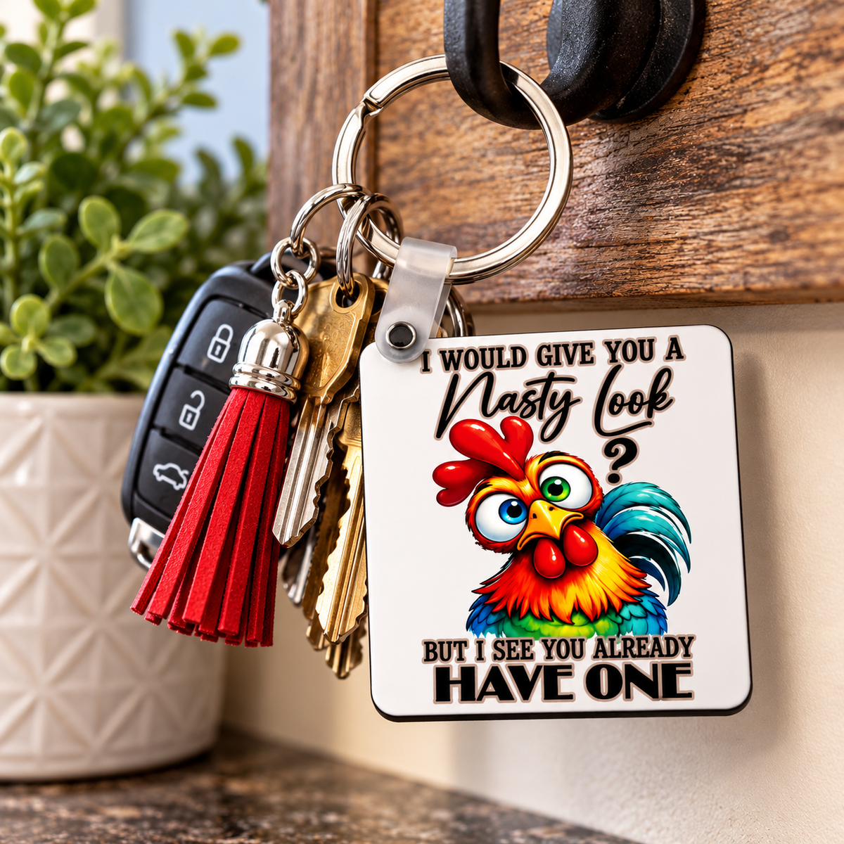 Funny novelty chicken keychain with colourful rooster design, metal key ring and tassel accessory shown with everyday keys.