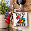Funny novelty chicken keychain with colourful rooster design, metal key ring and tassel accessory shown with everyday keys.