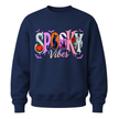 A navy blue crewneck sweatshirt featuring a colorful 'Spooky Vibes' graphic on the chest with Halloween-themed illustrations.