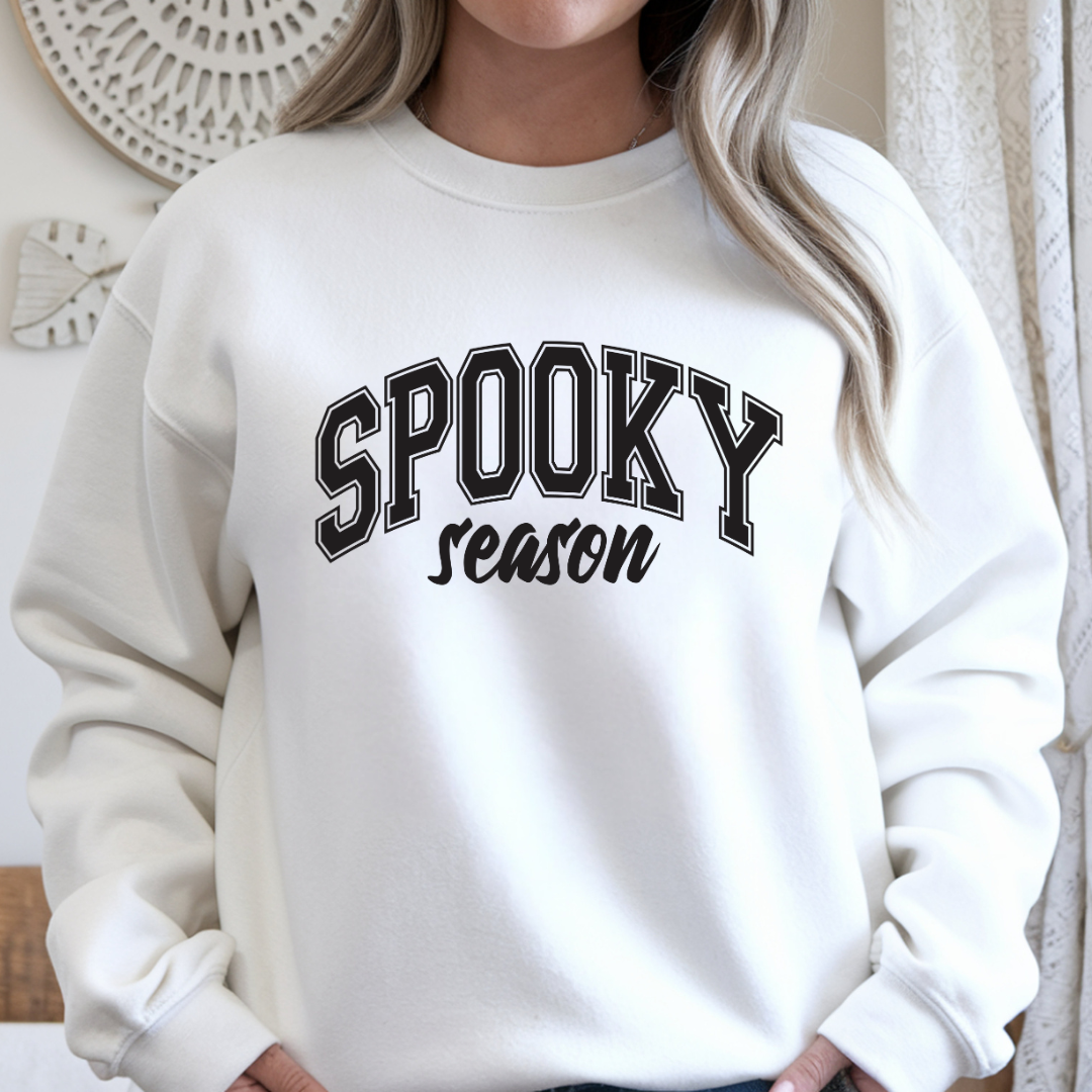 Woman modeling a white Spooky Season Halloween crewneck sweatshirt with bold black seasonal graphic