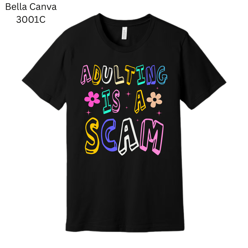 Black graphic T-shirt with bright rainbow text that says ‘Adulting Is a Scam.’ A humorous and relatable gift idea