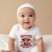 infant onesie displayed with baby clothing accessories and neutral background