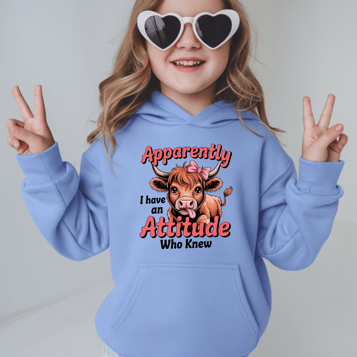 Carolina blue kids hoodie with funny cow illustration and playful attitude slogan for girls