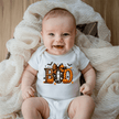 White Baby Boo Halloween Onesie featuring orange pumpkins, a cute ghost, bats, candy corn and decorative bow