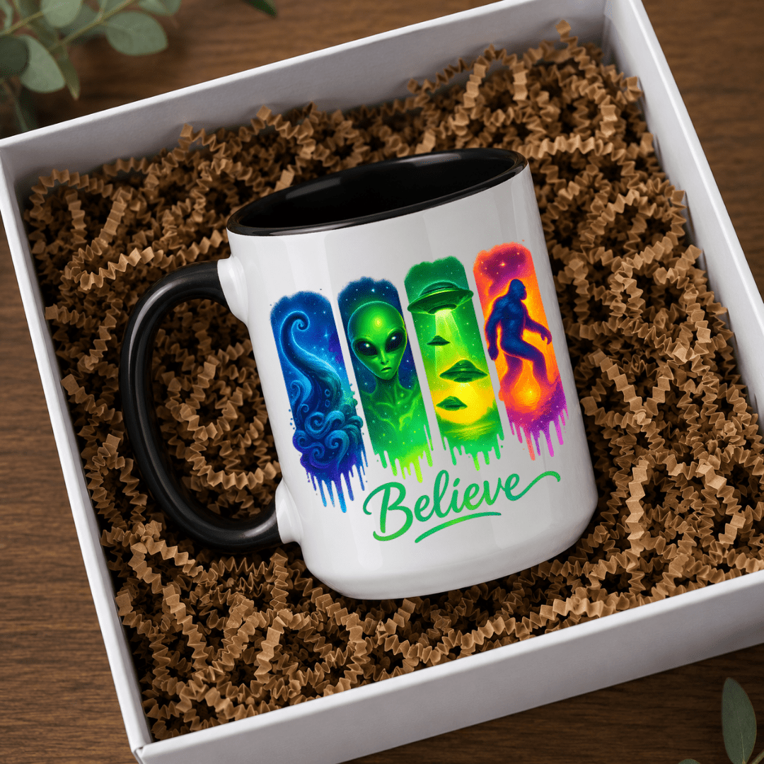 Believe alien UFO Bigfoot ceramic mug with black interior and handle featuring colourful paranormal and cryptid artwork.