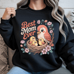 Black crewneck showcasing bold floral artwork and mother bird illustration.