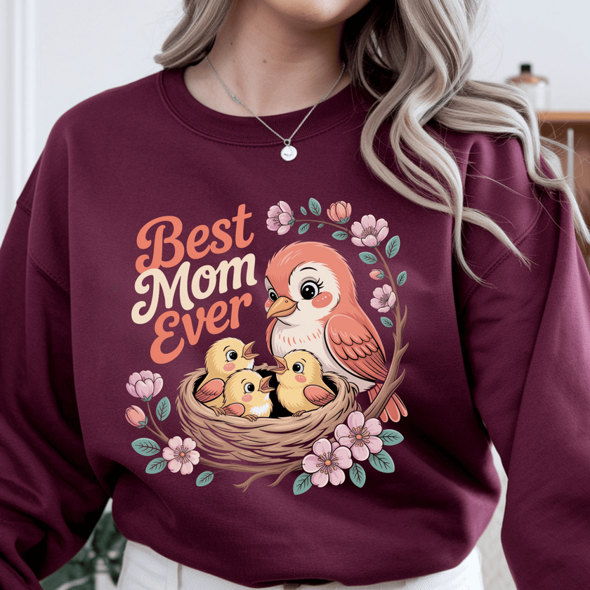 Maroon crewneck displaying colorful mother bird and nest artwork.