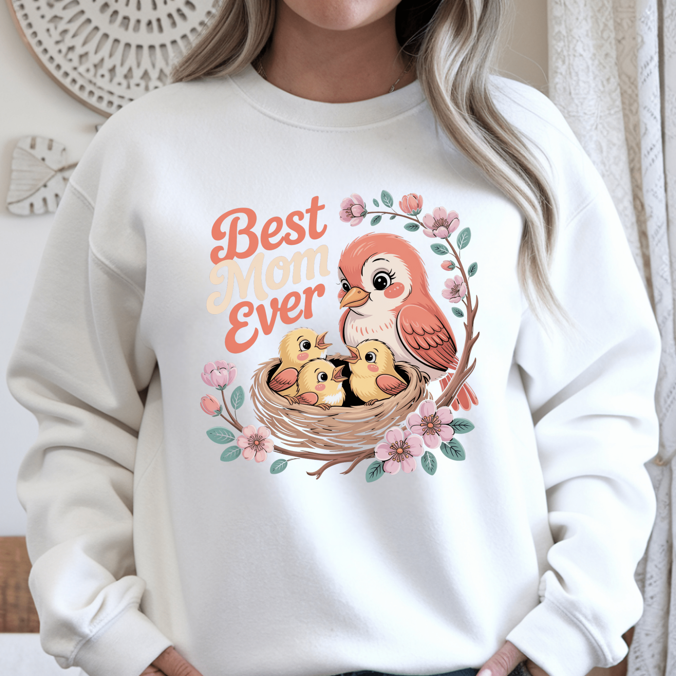 White crewneck sweater featuring colorful mother bird and baby birds with floral accents.