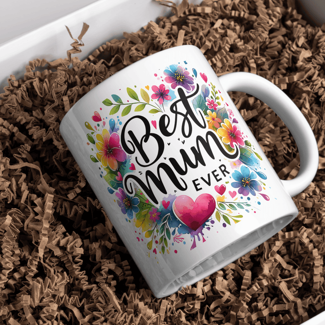 White mug with colorful text and floral designs on a brown crinkled paper background