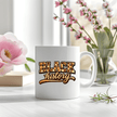 White ceramic Black History mug shown with soft floral background creating calm lifestyle aesthetic.