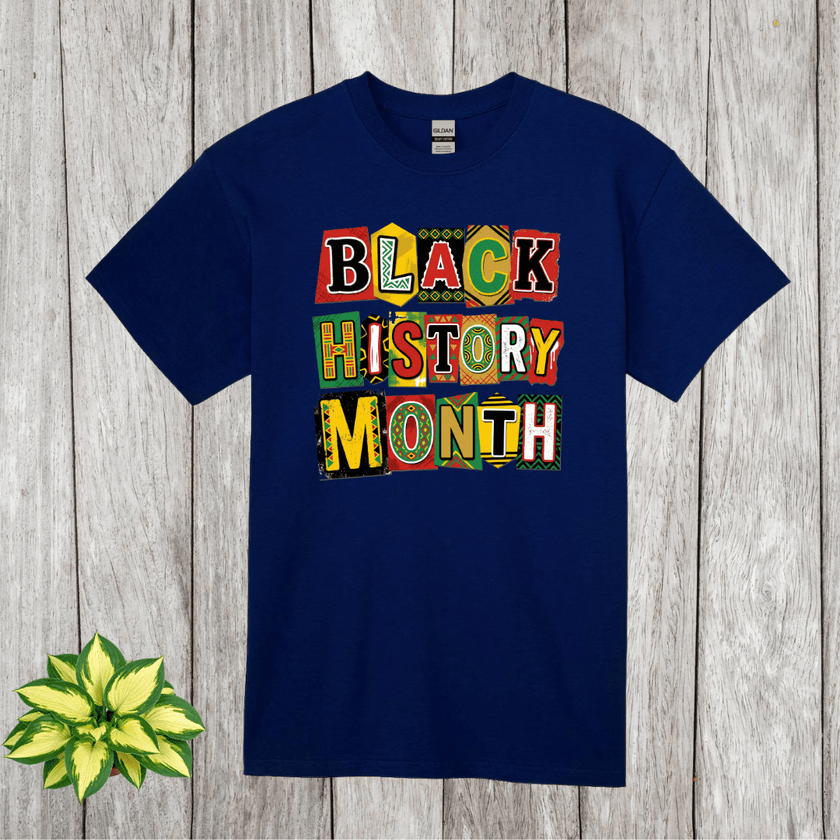 Navy blue t-shirt with 'Black History Month' text in colorful letters on a wooden surface.