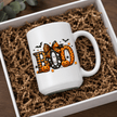 White ceramic BOO Halloween mug with pumpkins, ghosts, bats and candy corn in a cozy seasonal product mockup