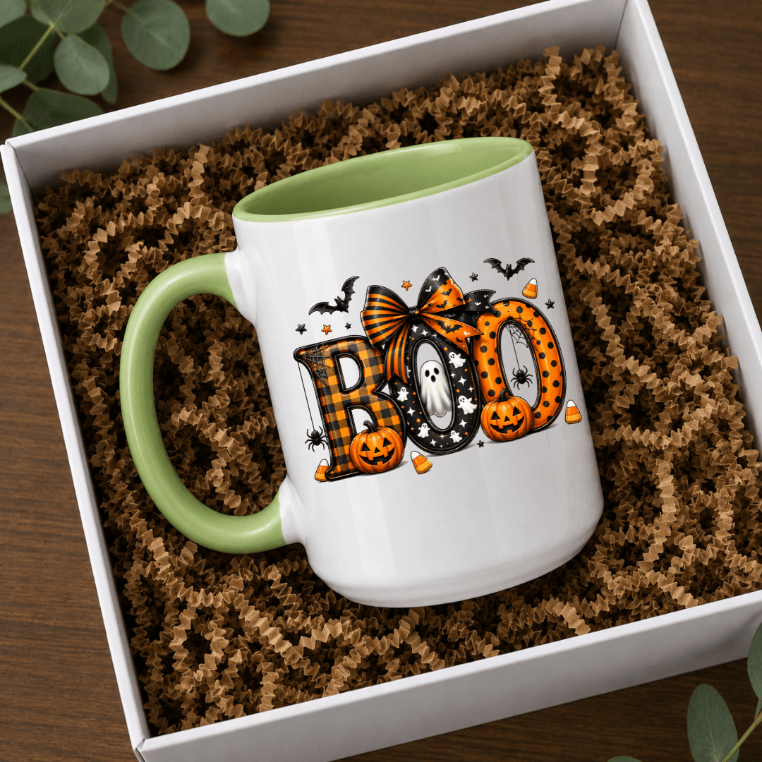 Green accent Halloween mug with BOO lettering, pumpkin details and ghost artwork styled in a gift box setting