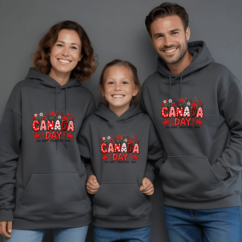 Family wearing charcoal grey Canada Day matching hoodies featuring patriotic maple leaf graphic design