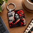 Horror fan key ring displayed on a dark desk with vivid red and black movie inspired artwork and silver metal key ring.