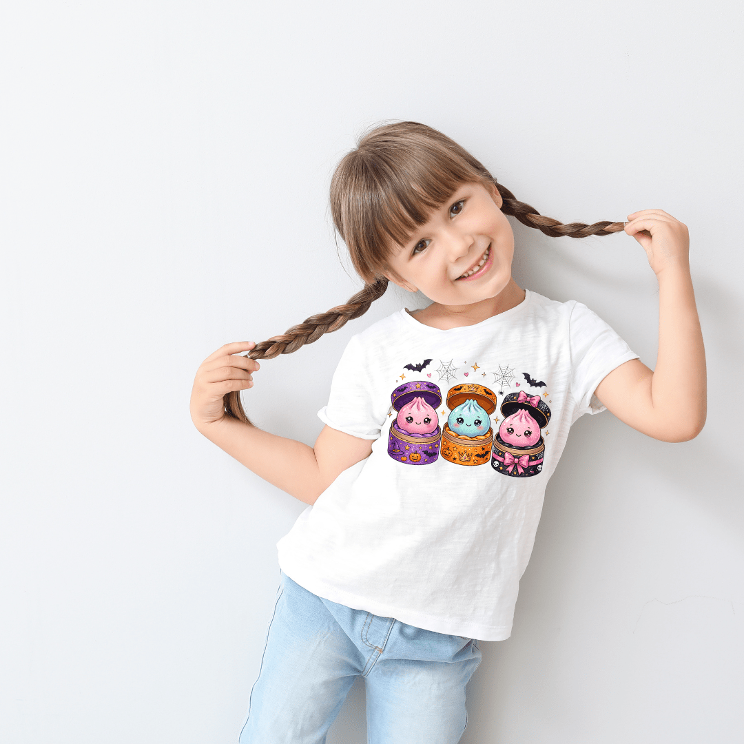 White kids Halloween graphic tee featuring colourful kawaii potion friends with cute bats, pumpkins and spooky fall details.