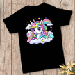 Cute black unicorn tee for girls featuring colorful kawaii rainbow unicorn artwork on a rustic wood backdrop.