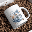 Cute snowman holding a hot cocoa mug with marshmallows on a white ceramic cup.