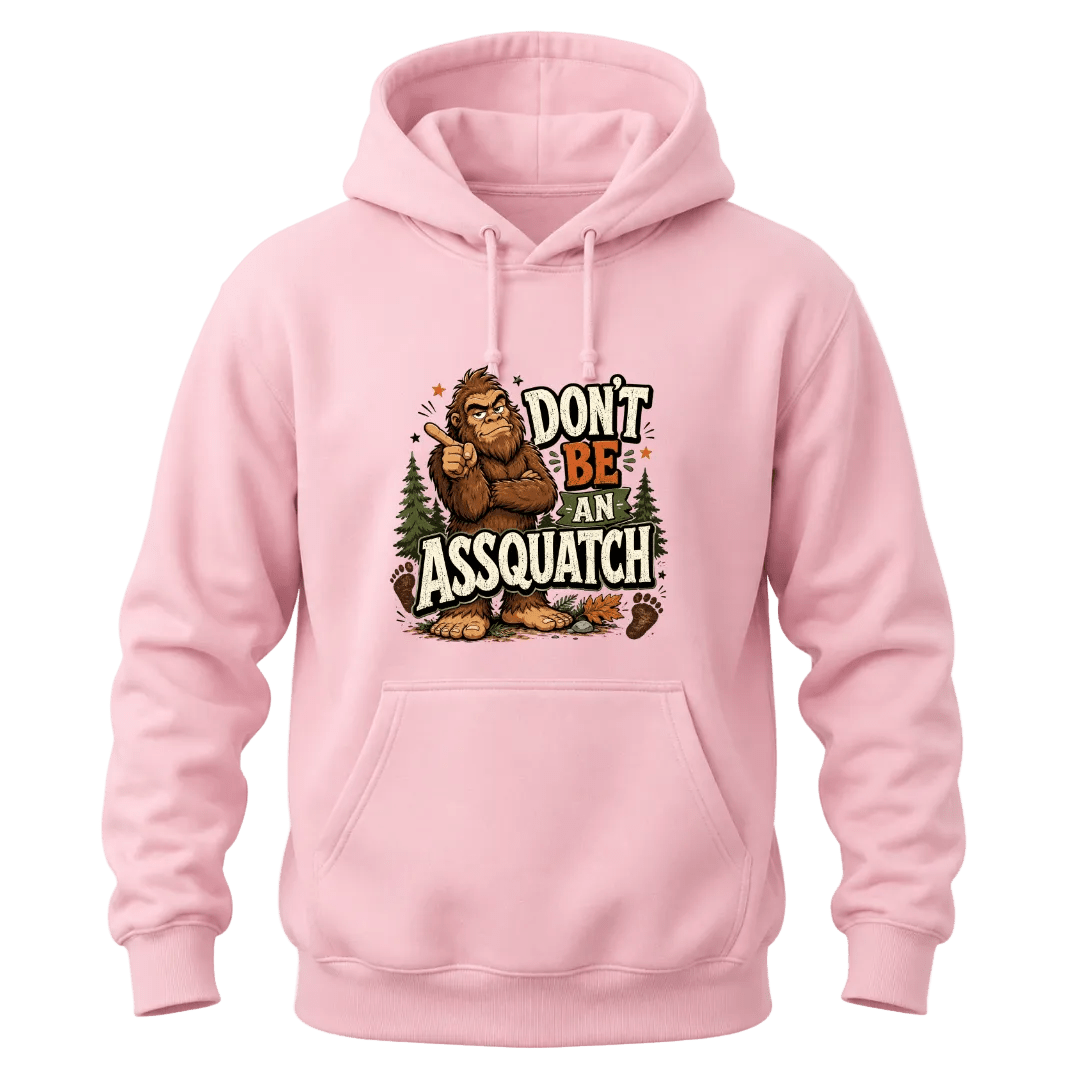 Light Pink Don’t Be An Assquatch hoodie with a funny Bigfoot character, forest details, and bold front chest print.