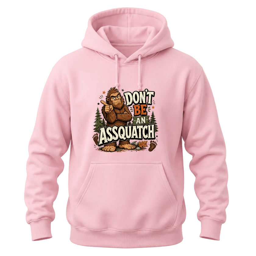 Light Pink Don’t Be An Assquatch hoodie with a funny Bigfoot character, forest details, and bold front chest print.