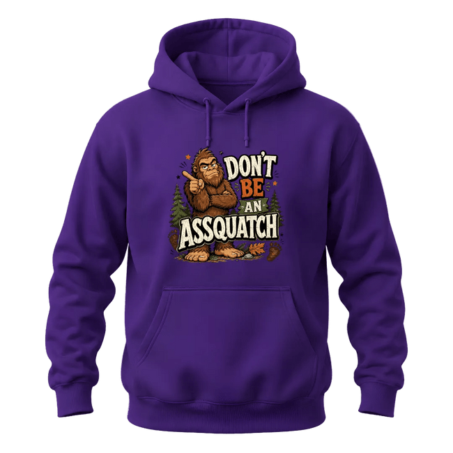 Purple graphic hoodie featuring a humorous Sasquatch design with pine trees, footprints, and Don’t Be An Assquatch lettering.