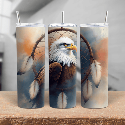 A 20oz and 30oz stainless steel tumbler featuring a detailed bald eagle inside a dreamcatcher with feathers.