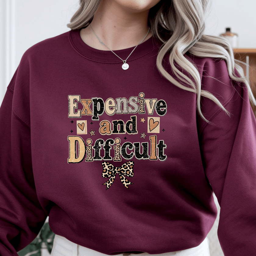 Maroon crewneck sweatshirt for women featuring Expensive and Difficult vintage typography graphic with leopard print bow design.