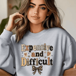 Light gray crewneck sweatshirt for women showcasing Expensive and Difficult statement graphic with leopard print bow and cozy casual fit.