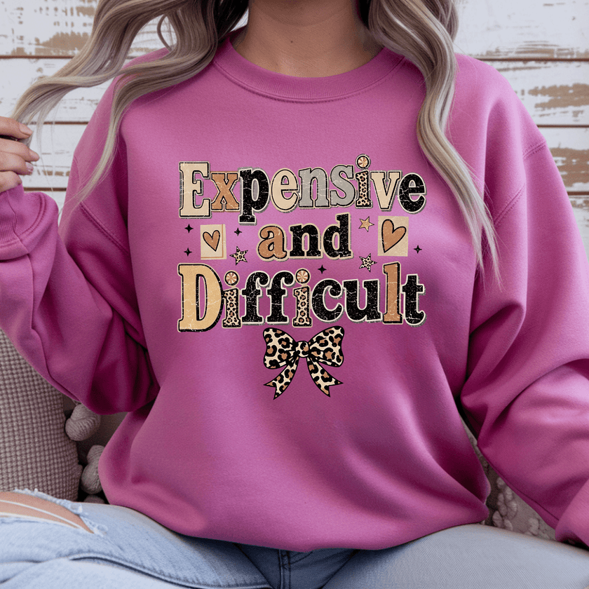 Comfortable women's crewneck sweater with Expensive and Difficult graphic print, leopard bow accent, and stylish everyday fashion look.