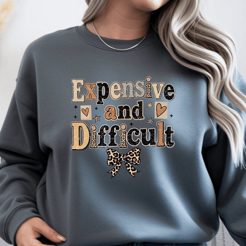 Charcoal gray women's crewneck sweatshirt featuring Expensive and Difficult graphic print with leopard bow accent and trendy boutique style.