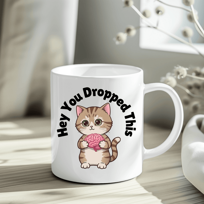 Funny cat illustration mug displayed in crinkle paper gift packaging.