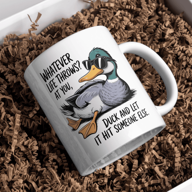 Funny novelty mug lying in packaging displaying humorous duck illustration and sarcastic quote.