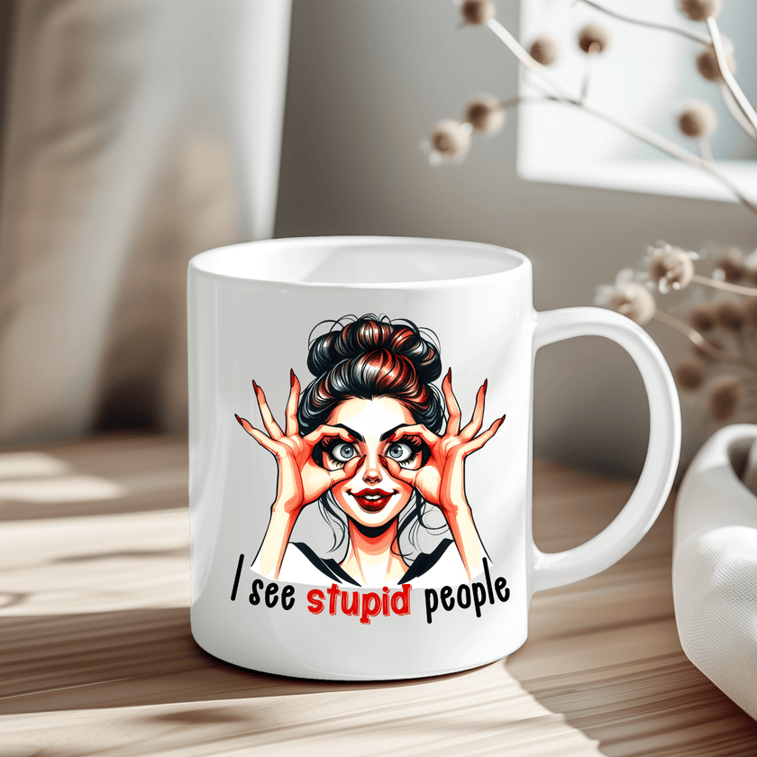 White ceramic mug featuring a cartoon woman with wide eyes and the phrase “I See Stupid People.”