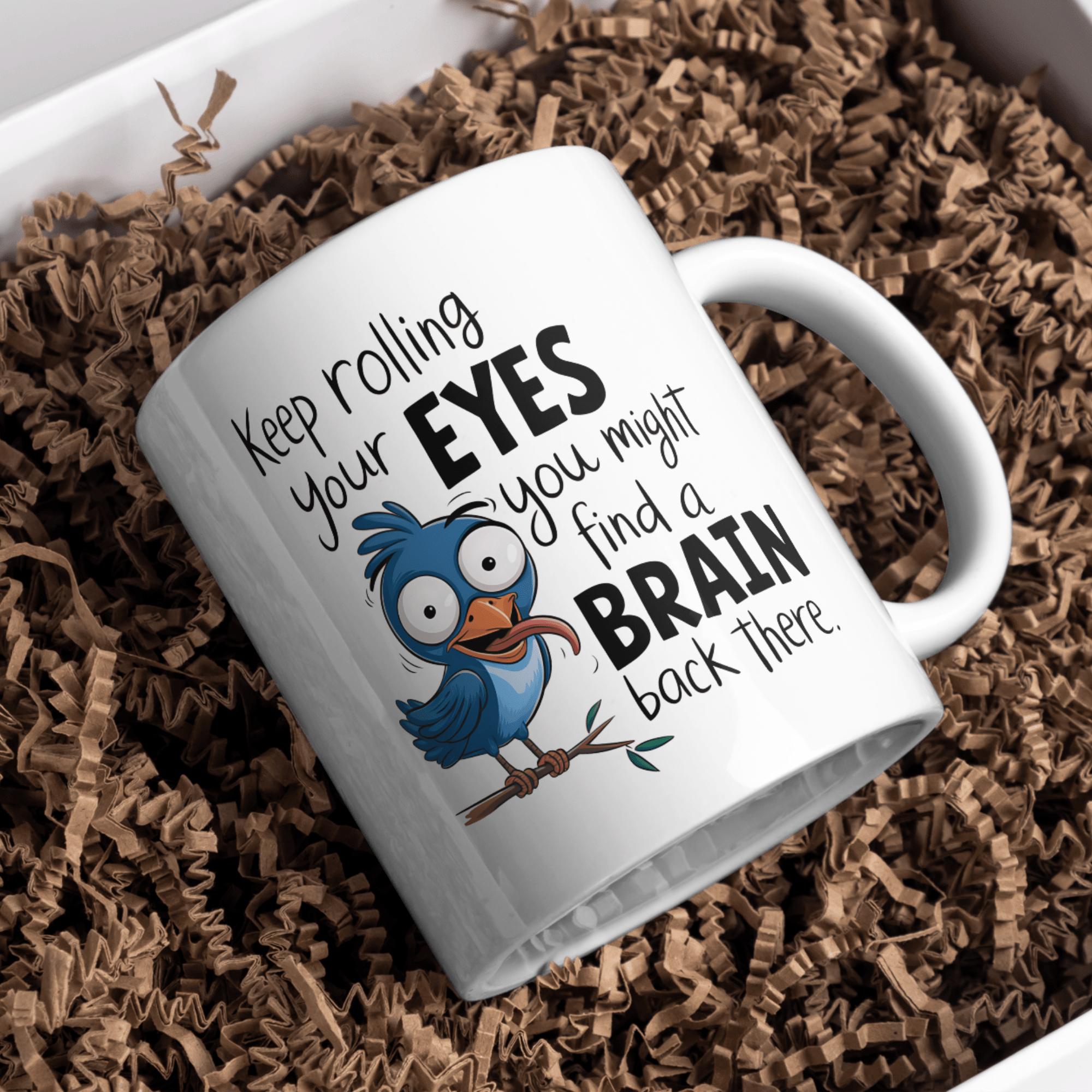 Ceramic mug featuring a funny blue bird and the sarcastic quote ‘Keep rolling your eyes, you might find a brain back there.'