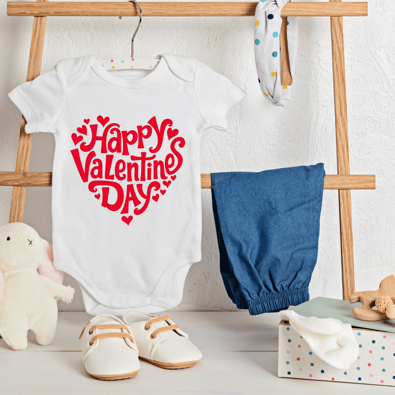 Baby Valentine onesie hanging on rack with nursery decor