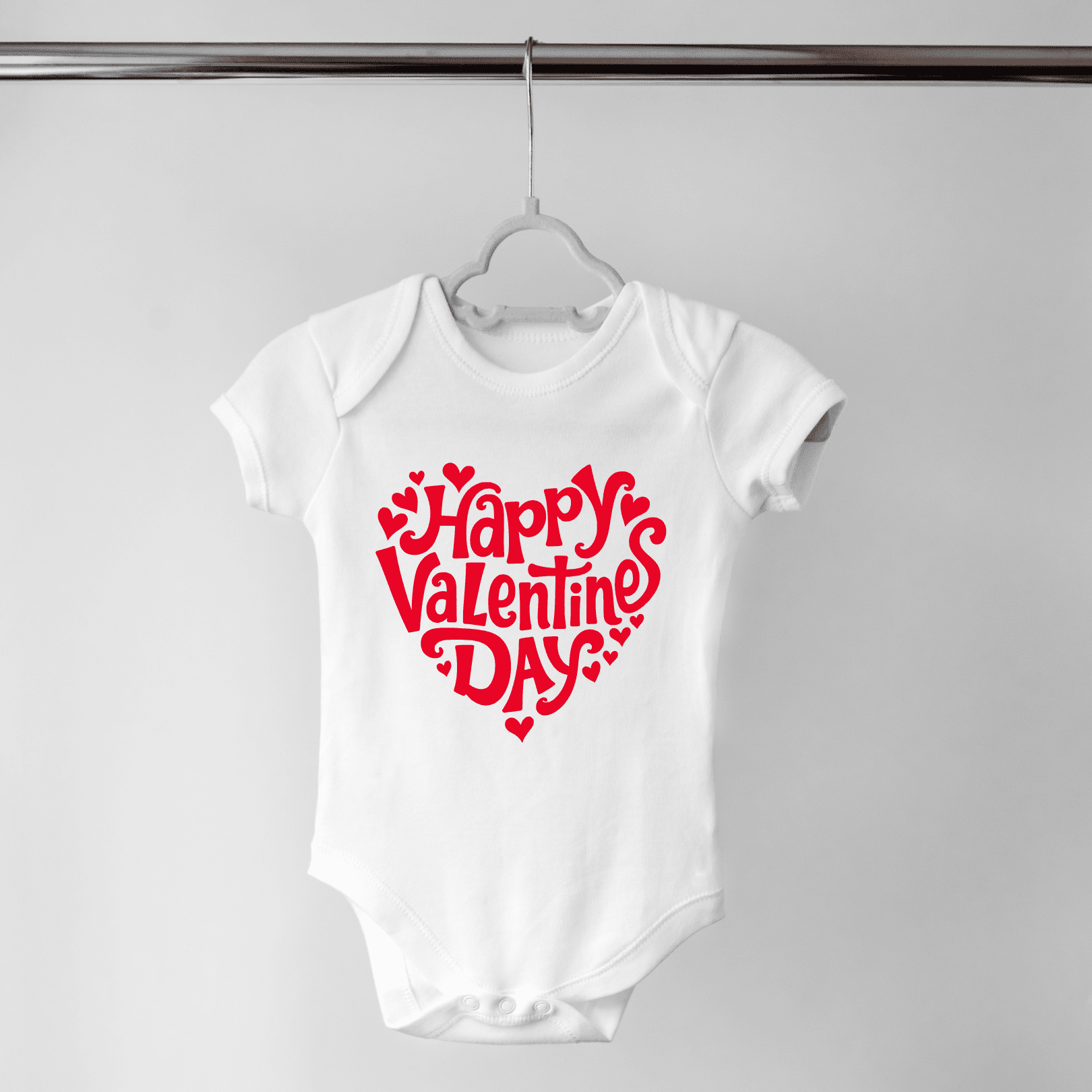 Close-up of red Valentine text on white baby onesie