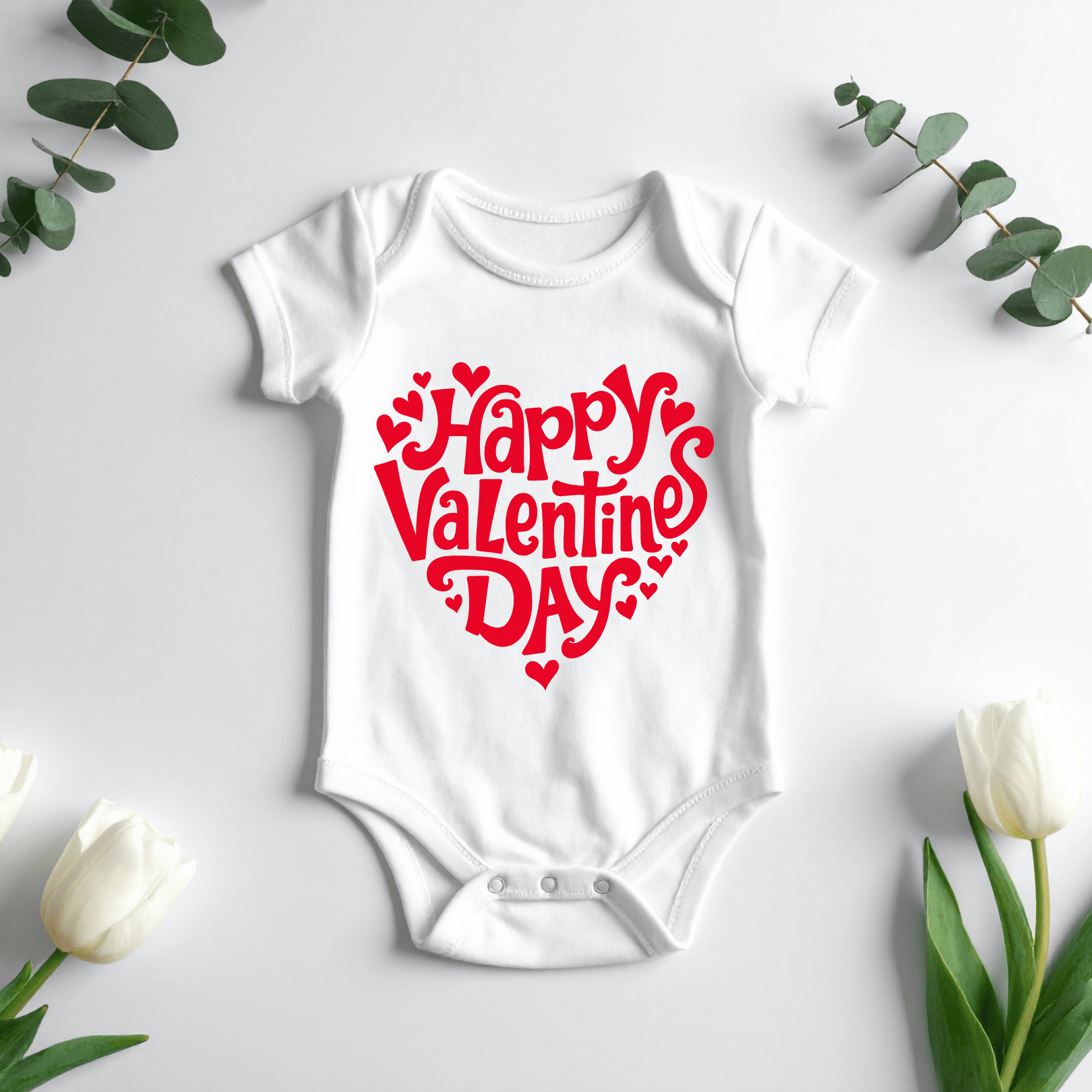 White Happy Valentine’s Day baby onesie with red heart design laid flat