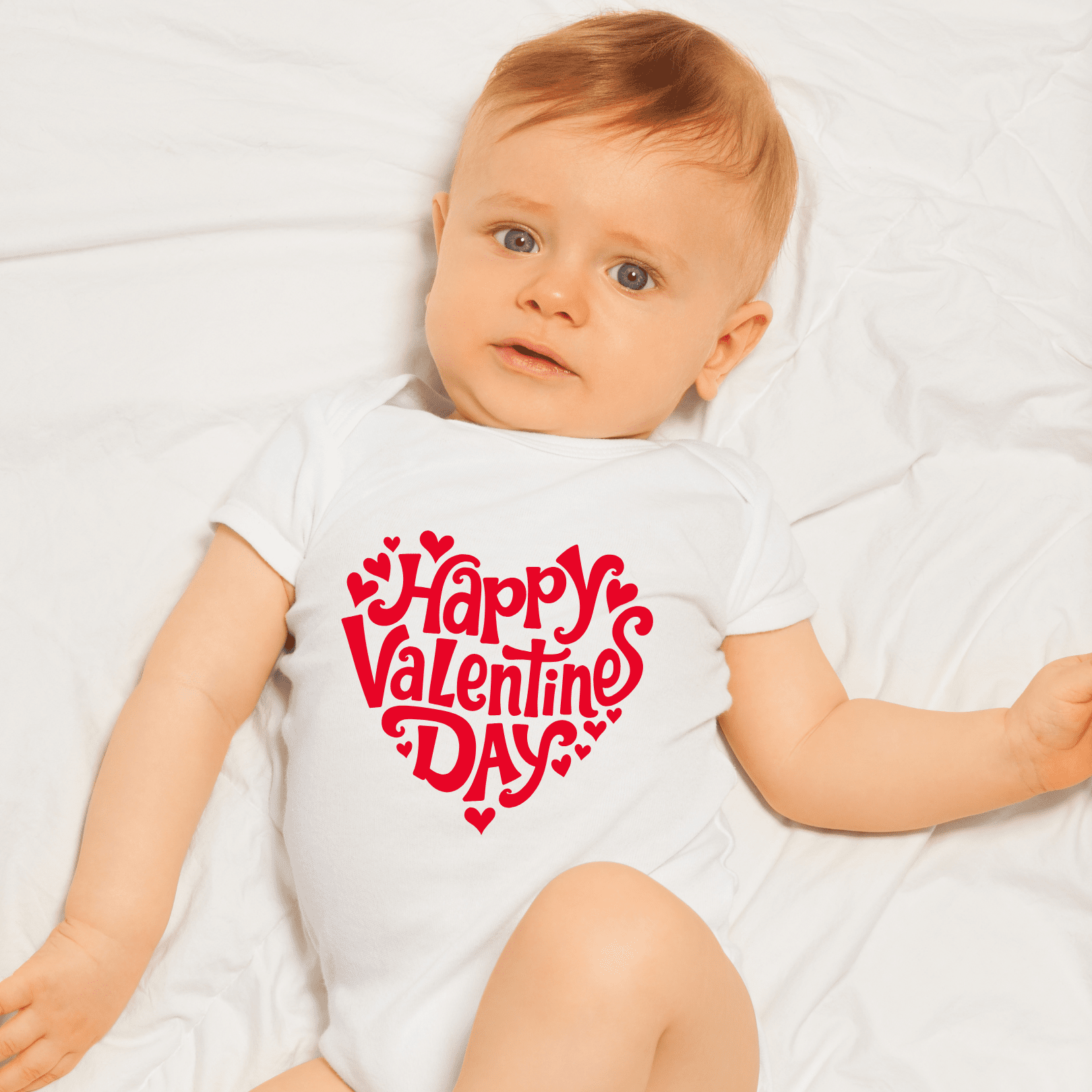 Infant wearing Happy Valentine’s Day onesie during photoshoot