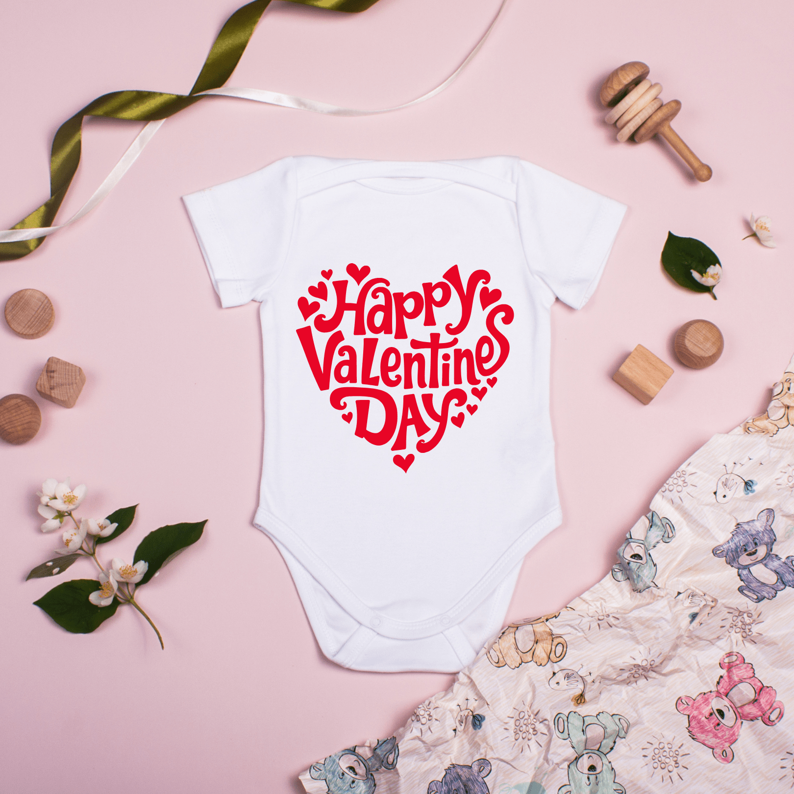 Cute Valentine’s Day baby bodysuit displayed on flat background