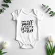 Cute infant outfit with I May Be Small But I'm The Boss phrase and footprint details for newborn photos