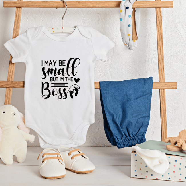White baby onesie featuring I May Be Small But I'm The Boss quote with footprint graphic for newborn outfit
