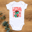 Baby outfit flat lay featuring I Steal Hearts graphic onesie