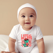 Newborn wearing dinosaur baby onesie for Valentine’s Day