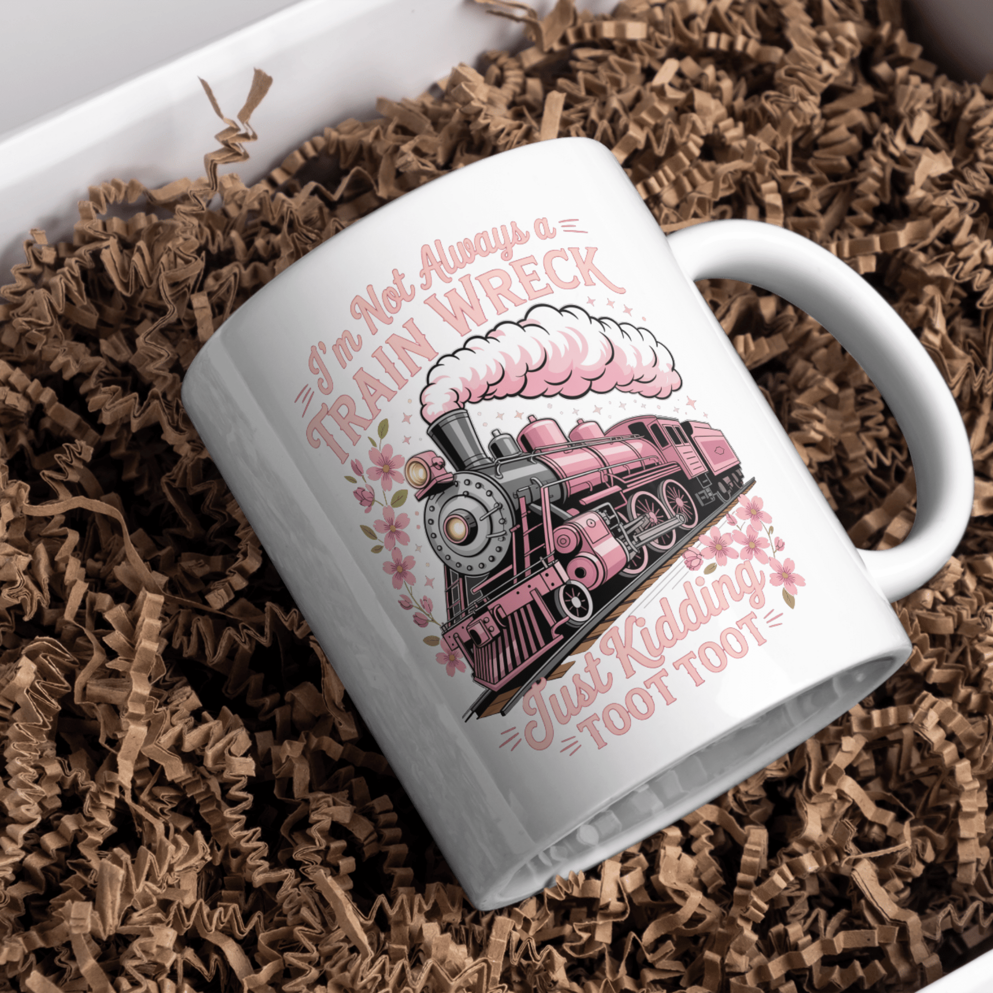 White ceramic mug with pink train illustration and funny train wreck quote design on crinkle paper background