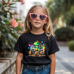 Black tee girls T shirt featuring a cute dinosaur riding in a monster truck with colorful adventure details.