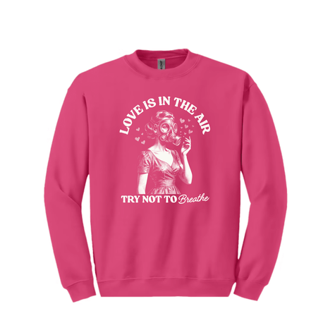 Pink crewneck sweatshirt with humorous Love Is In The Air retro Valentine graphic printed on front