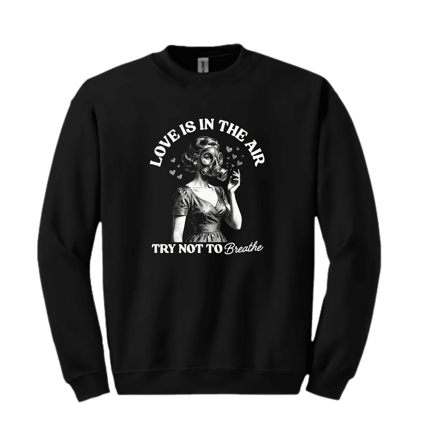 Black crewneck sweatshirt displaying retro gas mask illustration with humorous Love Is In The Air text