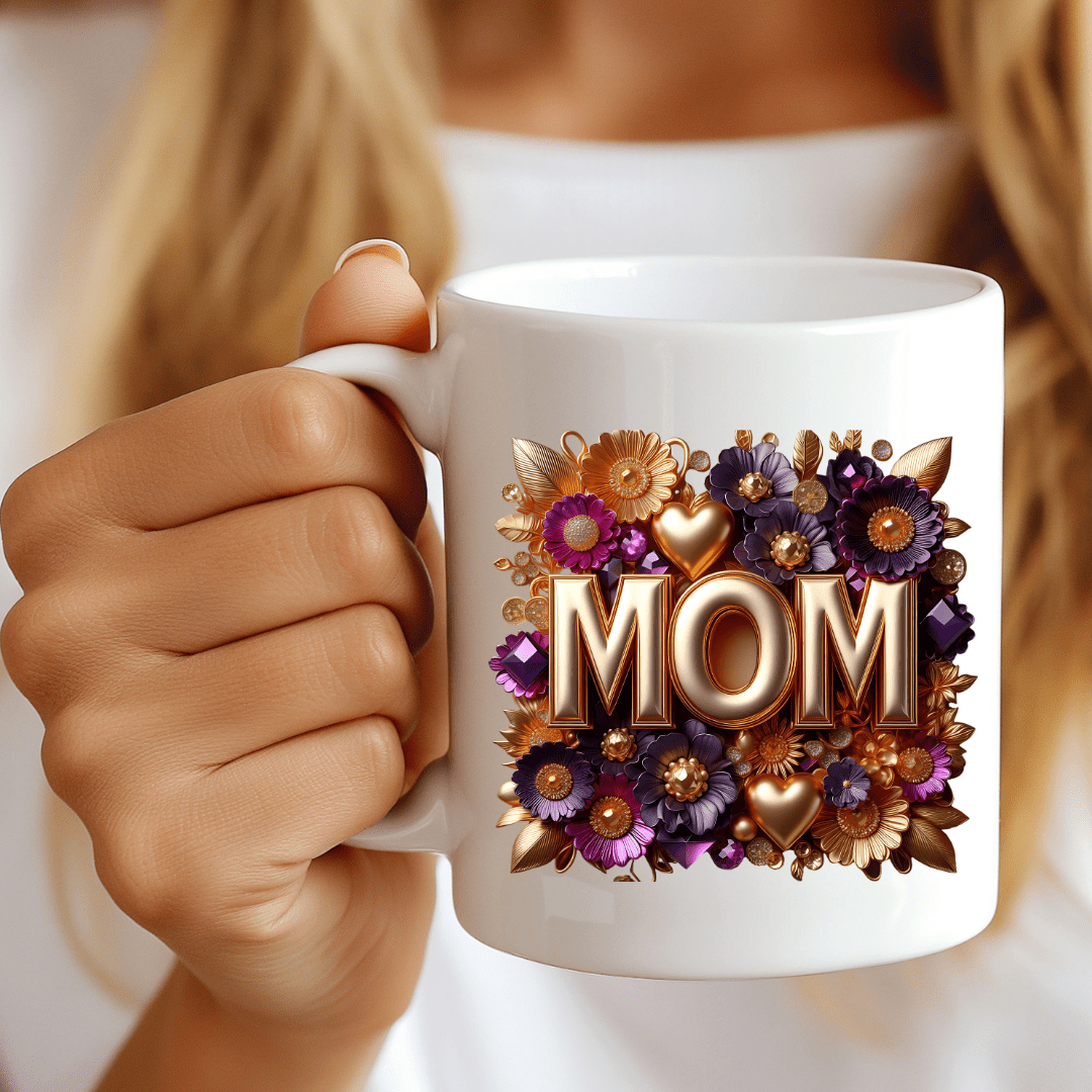 Close-up of MOM coffee mug with purple and gold flowers held in hand lifestyle shot