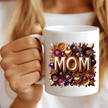 Close-up of MOM coffee mug with purple and gold flowers held in hand lifestyle shot