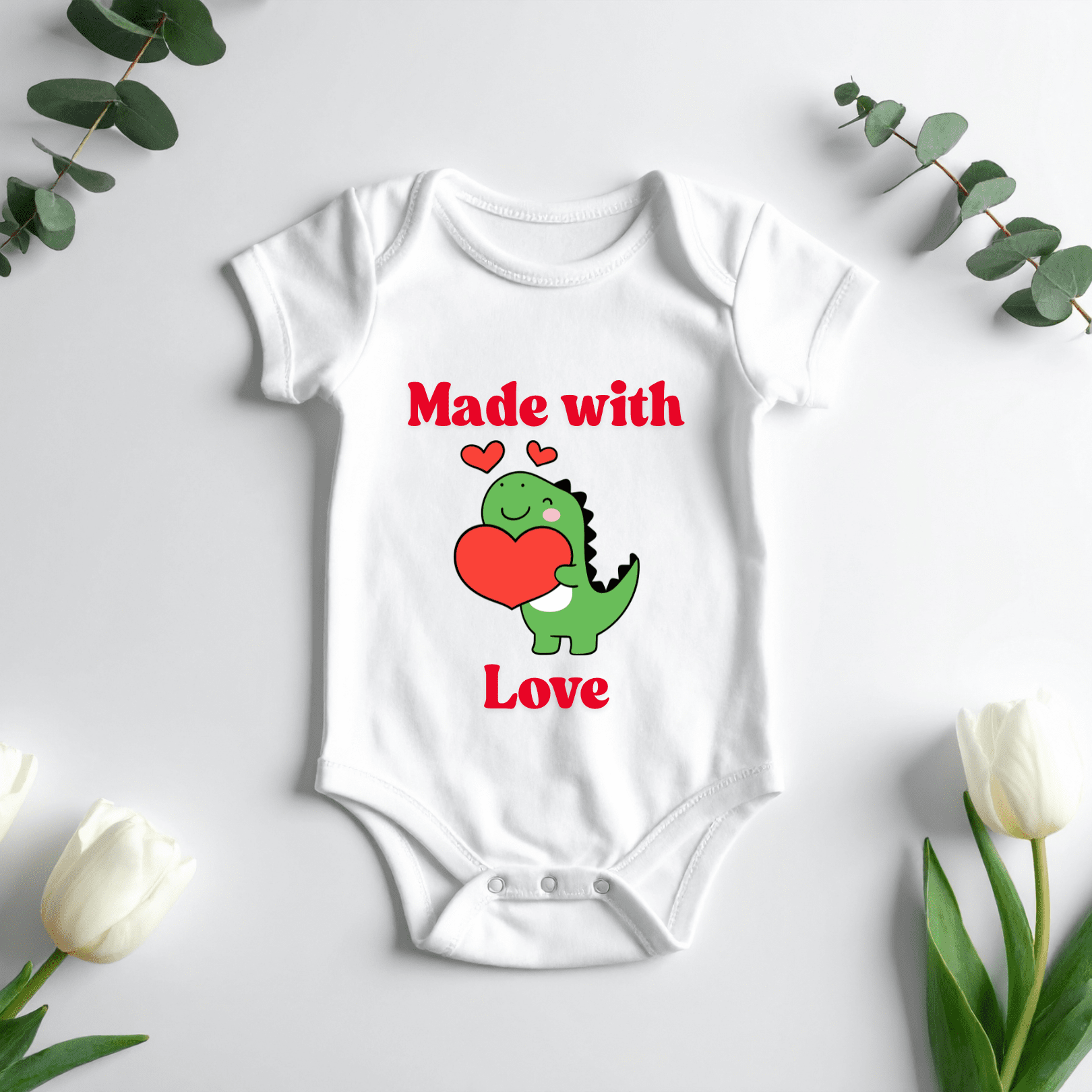 Baby onesie with Made with Love text and cute dinosaur holding heart